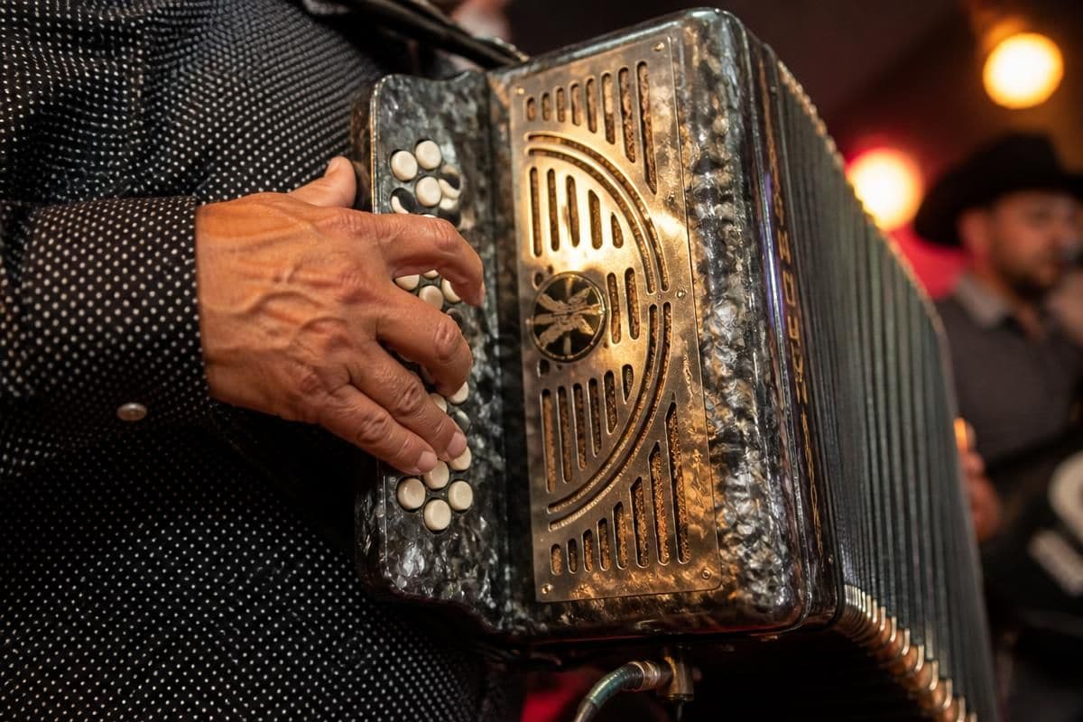 Close-up of the El Kompa Roger accordionist playing classic norteño songs at a Chicago party